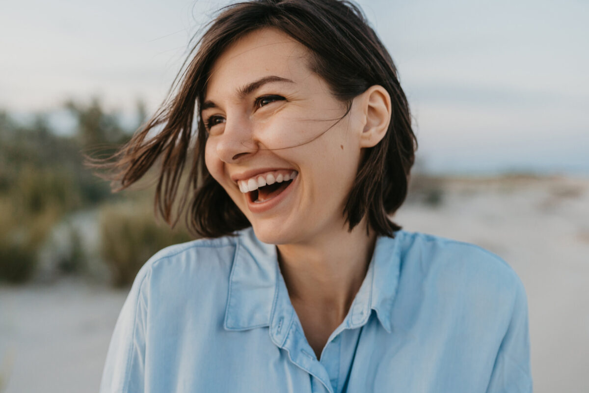 smiling portrait of candid laughing woman on the beach summer vacation happy mood